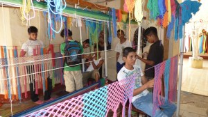 Gutar som jobbar på ein hengekøye-fabrikk.